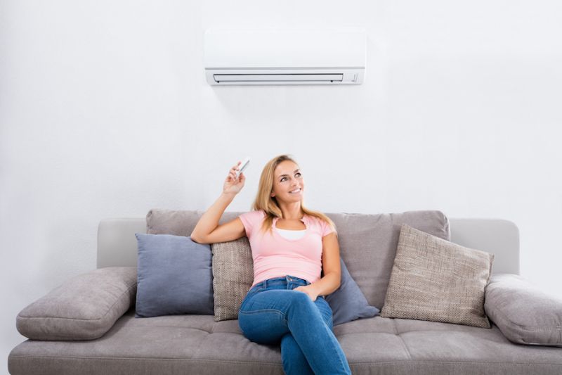 Image of a person sitting below Ductless system. Ductless AC's Improve Indoor Air Quality and Control Humidity.