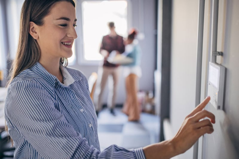 Young woman changing temperature on thermometer in the office.