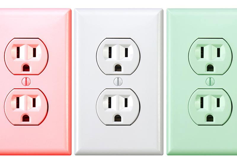 Three duplex electrical wall outlets in pink, white, and green.