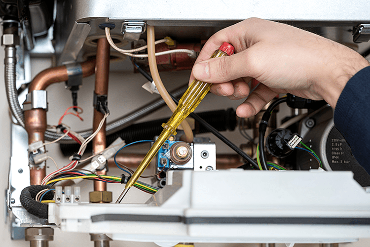 When Do I Know It's Time To Buy a New Furnace? HVAC worker repairing furnace.