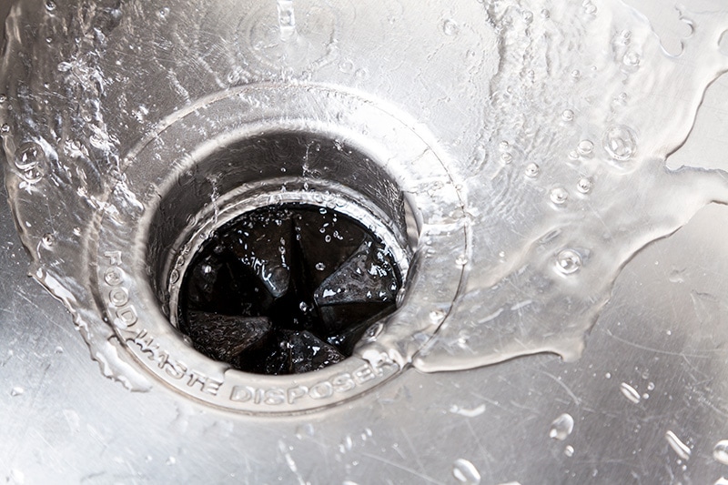 Water splashing into a stainless steel kitchen sink, Plumbing Tips to Remember This Fall | Winston-Salem, NC | Sutton Bros.