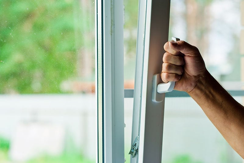 Man opens the plastic window to let in fresh spring air, Indoor Air Quality