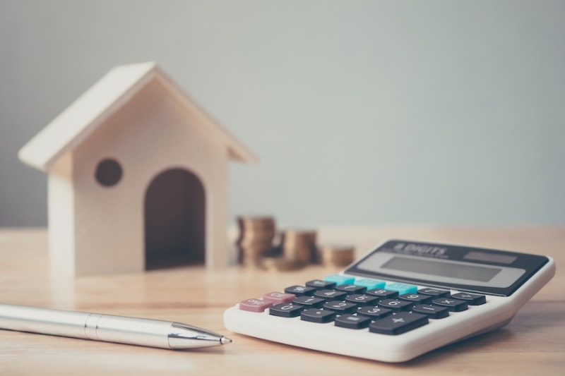 Calculator and wooden house on desk