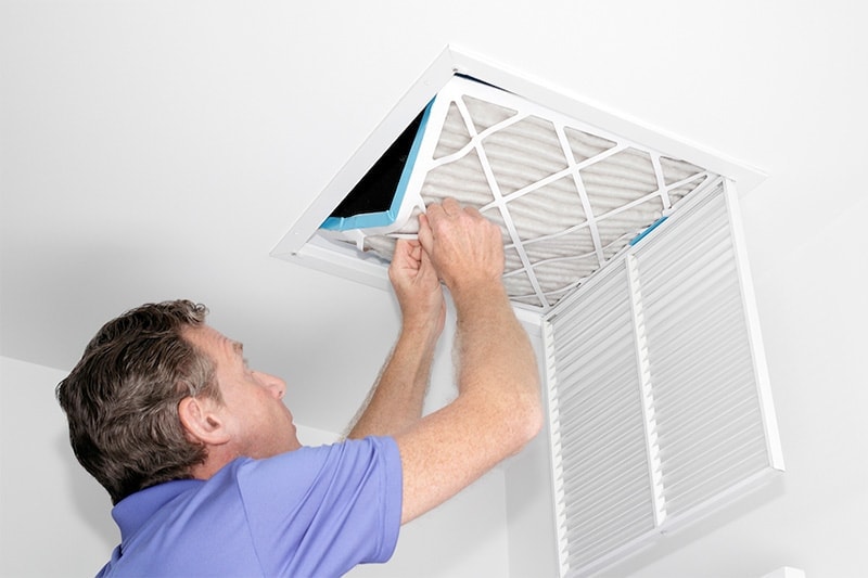 Middle aged man replacing fillter, Do Air Filters Work? | Indoor Air Quality, HVAC Service | Kernersville, NC