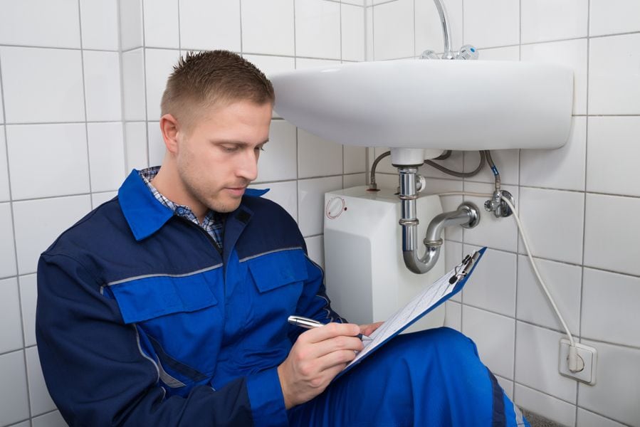 Do I Need a Plumbing Inspection? Image shows plumbing professional inspecting sink.