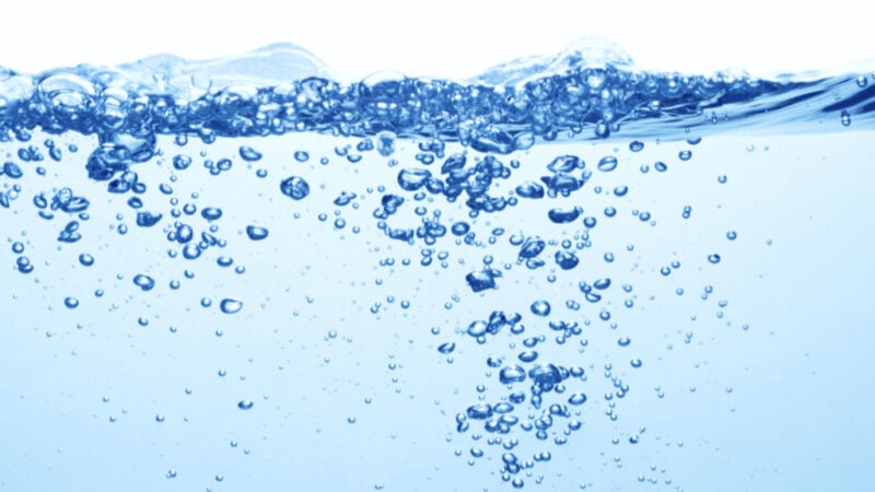 clean blue water with air bubbles and splashes on white background indicating water quality